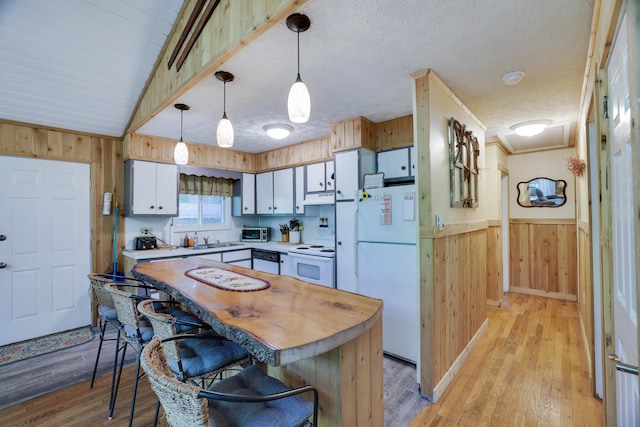 354 Fawn Rd, Pocono Lake, PA 18347 - kitchen with white appliances, wooden walls, under cabinet range hood, butcher block countertops, and light wood-style flooring
