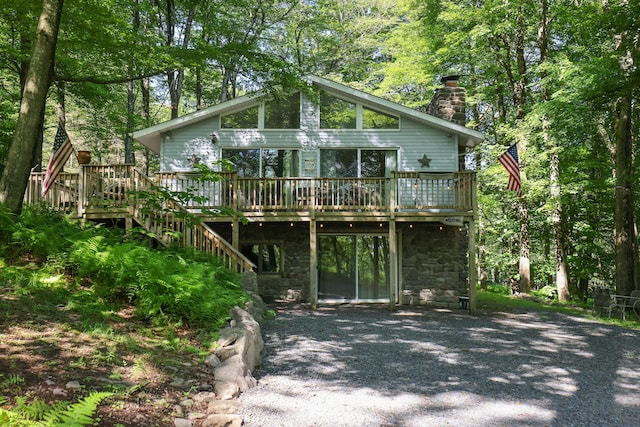 354 Fawn Rd, Pocono Lake, PA 18347 - view of front of home featuring a wooden deck, a chimney, stone siding, a carport, and stairs