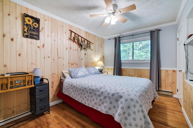 354 Fawn Rd, Pocono Lake, PA 18347 - bedroom featuring wooden walls, ornamental molding, wood finished floors, a baseboard radiator, and a wainscoted wall
