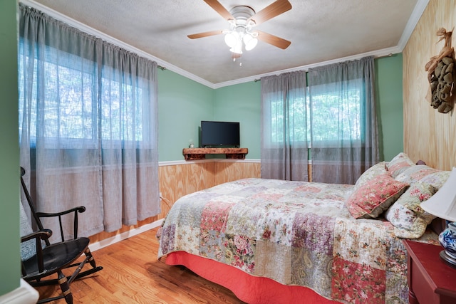354 Fawn Rd, Pocono Lake, PA 18347 - bedroom featuring multiple windows, wood finished floors, crown molding, ceiling fan, and wainscoting