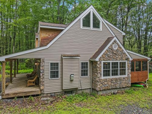 141 Beech Ln, Pocono Lake, PA 18347 - rear view of house featuring stone siding, a sunroom, and a wooden deck