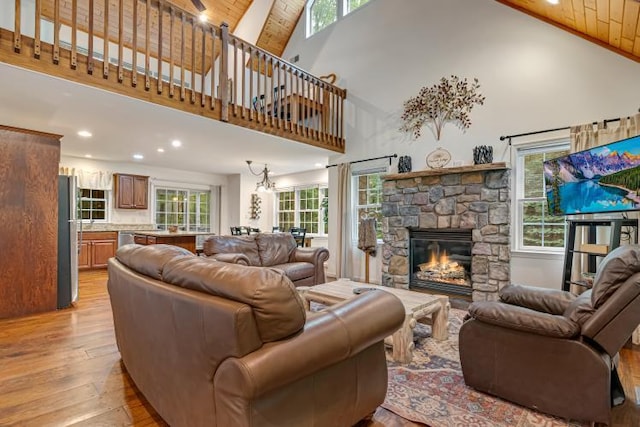 141 Beech Ln, Pocono Lake, PA 18347 - living area with high vaulted ceiling, healthy amount of natural light, light wood-style flooring, a stone fireplace, and wooden ceiling