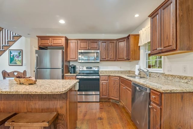141 Beech Ln, Pocono Lake, PA 18347 - kitchen featuring stainless steel appliances, dark wood-style floors, light stone countertops, a breakfast bar area, and recessed lighting