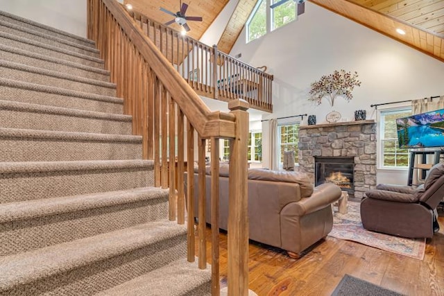 141 Beech Ln, Pocono Lake, PA 18347 - living room with wood-type flooring, high vaulted ceiling, ceiling fan, stairs, and a stone fireplace