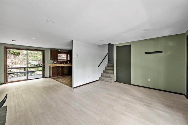 6061 Decker Rd, Bushkill, PA 18324 - unfurnished living room with stairs, baseboards, and light wood-type flooring