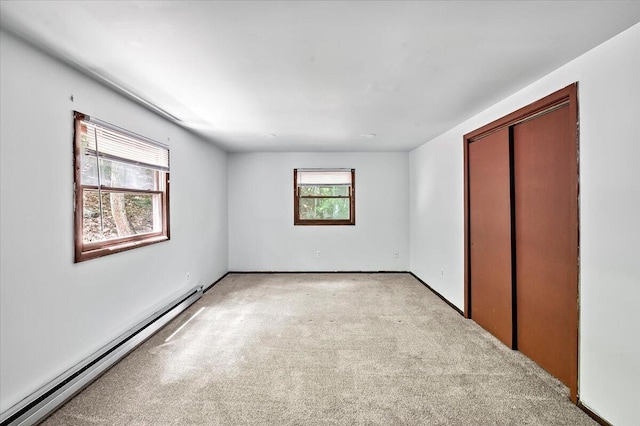 6061 Decker Rd, Bushkill, PA 18324 - unfurnished bedroom with a baseboard heating unit, light colored carpet, a closet, and baseboards