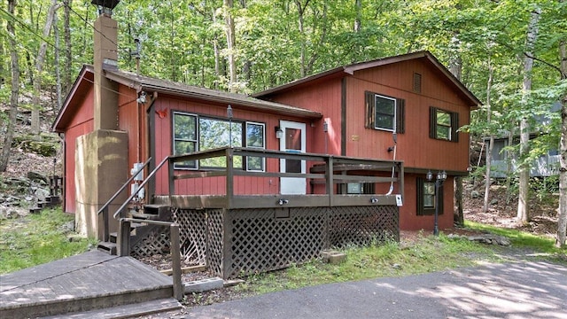 6061 Decker Rd, Bushkill, PA 18324 - view of front of property with a chimney, a deck, and a view of trees