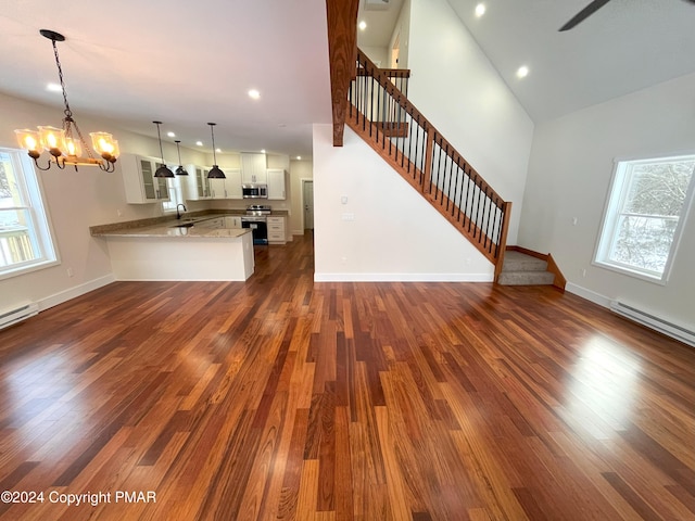 unfurnished living room featuring a notable chandelier, baseboards, stairway, and dark wood-style flooring