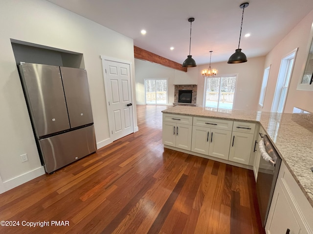 kitchen featuring light stone counters, dark wood finished floors, appliances with stainless steel finishes, open floor plan, and white cabinets