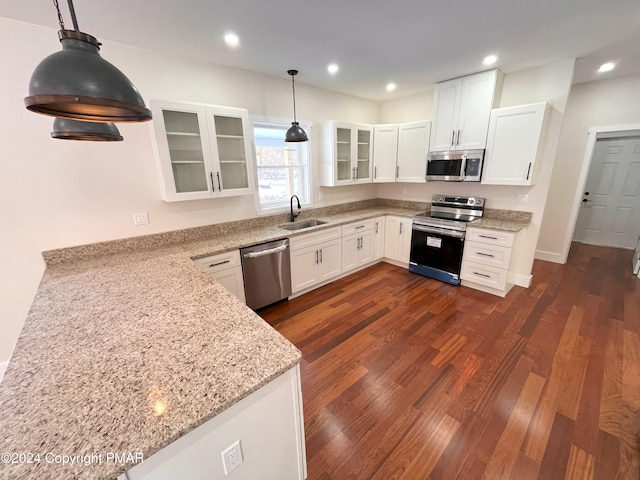 kitchen with light stone counters, dark wood-style flooring, appliances with stainless steel finishes, glass insert cabinets, and a sink