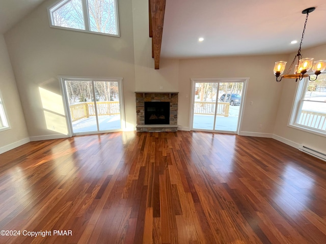 unfurnished living room featuring wood finished floors, a wealth of natural light, and a notable chandelier