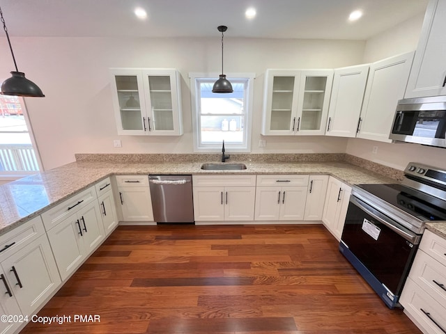 kitchen featuring stainless steel appliances, dark wood-type flooring, a sink, and white cabinetry