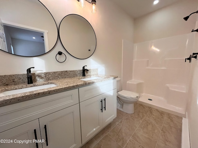 bathroom with toilet, double vanity, a shower, and a sink