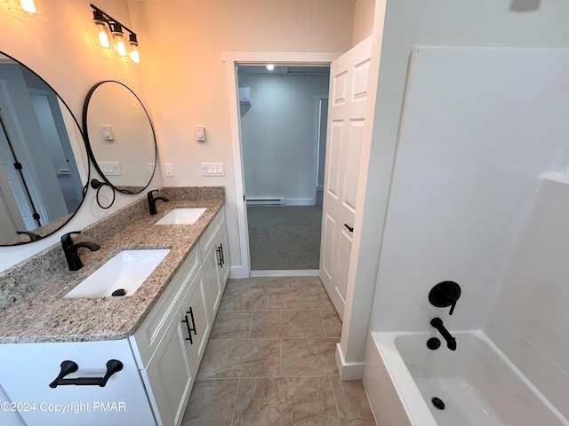 bathroom with double vanity, baseboards, a baseboard heating unit, and a sink