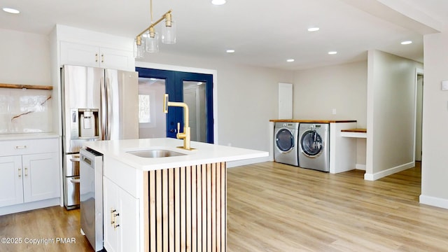 182 Mallard Ln, Albrightsville, PA 18210 - kitchen with light wood-type flooring, stainless steel appliances, separate washer and dryer, and a sink