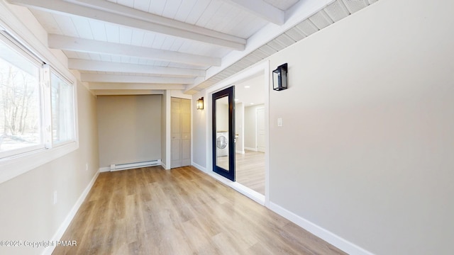 182 Mallard Ln, Albrightsville, PA 18210 - empty room featuring a baseboard heating unit, beamed ceiling, stacked washing maching and dryer, and baseboards