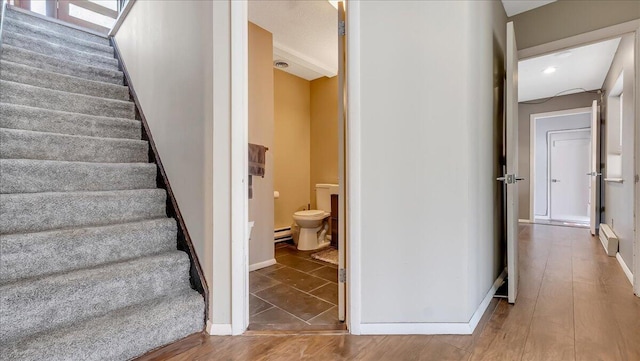 3206 Stonehenge Dr, East Stroudsburg, PA 18301 - staircase featuring baseboards, a baseboard heating unit, and wood finished floors