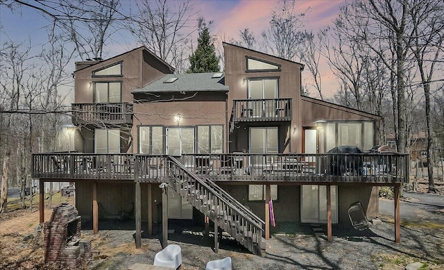 3206 Stonehenge Dr, East Stroudsburg, PA 18301 - back of property at dusk with a balcony, stairway, and a deck