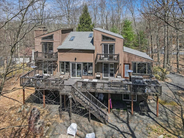 3206 Stonehenge Dr, East Stroudsburg, PA 18301 - rear view of house with a balcony, a deck, roof with shingles, a chimney, and stairway