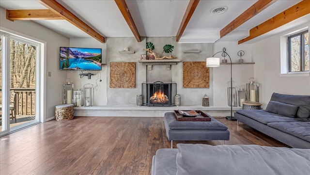3206 Stonehenge Dr, East Stroudsburg, PA 18301 - living room featuring beamed ceiling, a warm lit fireplace, wood finished floors, and visible vents