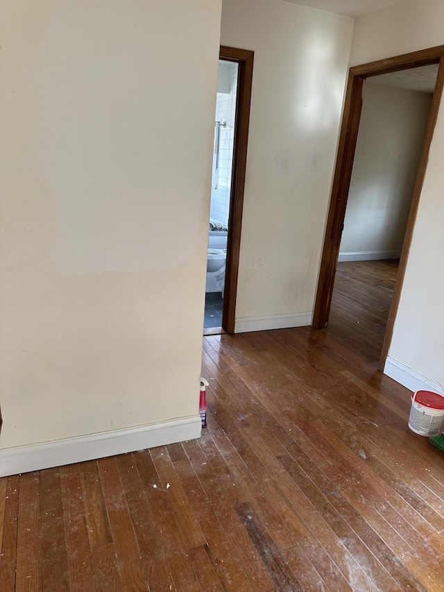 spare room featuring baseboards and hardwood / wood-style flooring