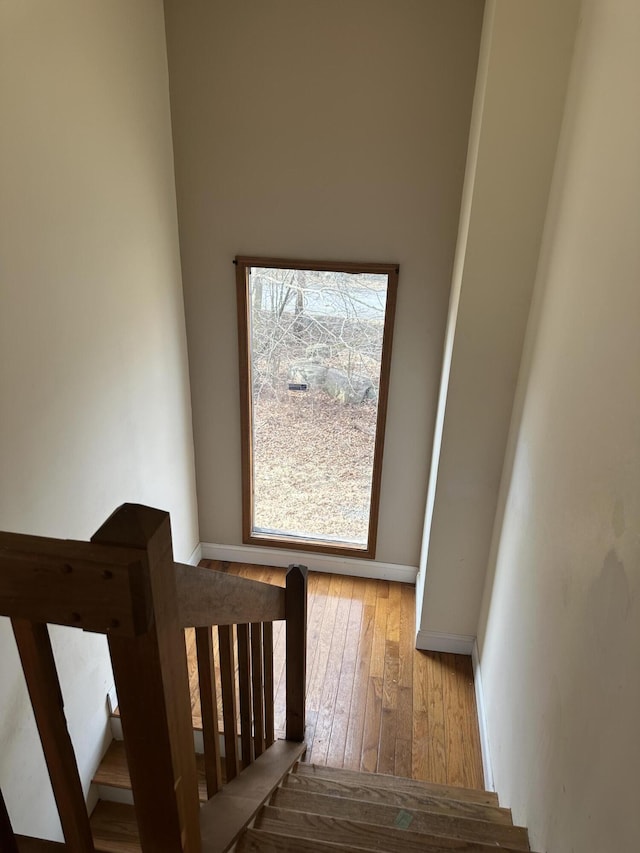 staircase featuring baseboards and wood-type flooring