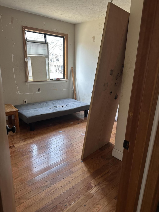 unfurnished bedroom featuring a textured ceiling and hardwood / wood-style floors