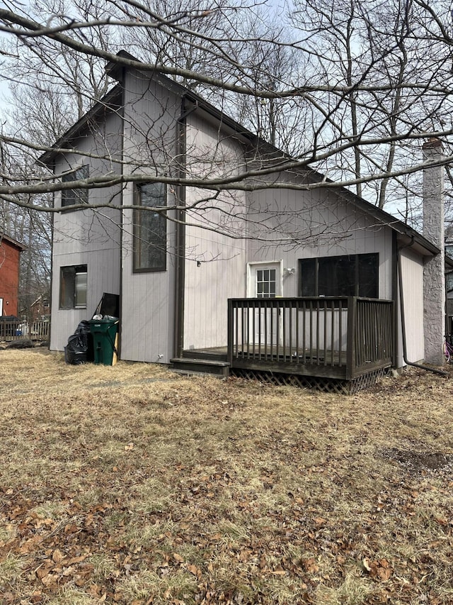 back of house featuring a chimney and a wooden deck