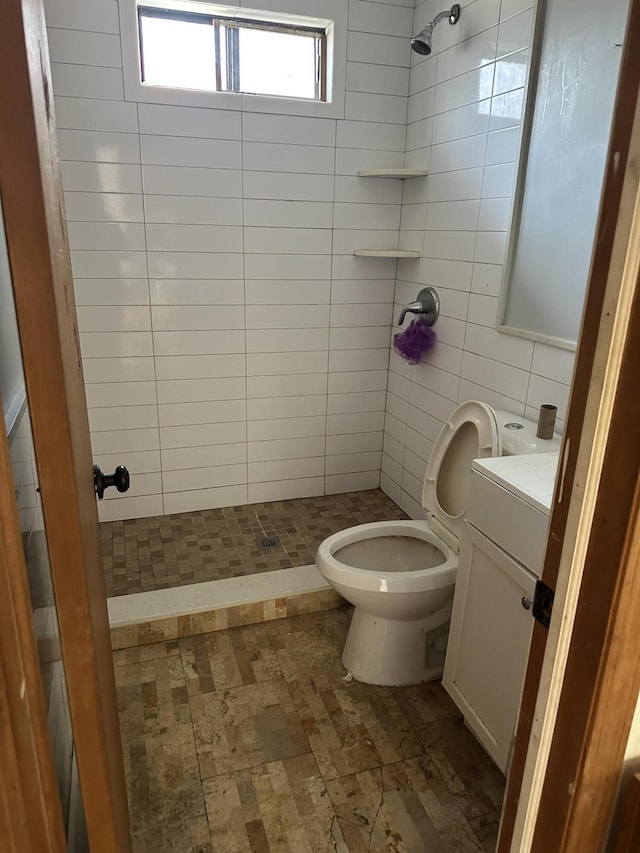 full bathroom with vanity, tile walls, toilet, and a stall shower