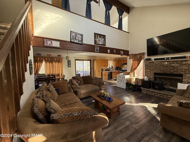 living area featuring wood finished floors, high vaulted ceiling, beam ceiling, a fireplace, and stairs