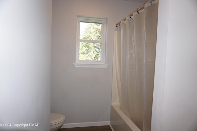 bathroom featuring shower / bath combo and toilet