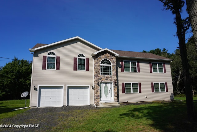 view of front of house featuring stone siding, an attached garage, gravel driveway, and a front yard