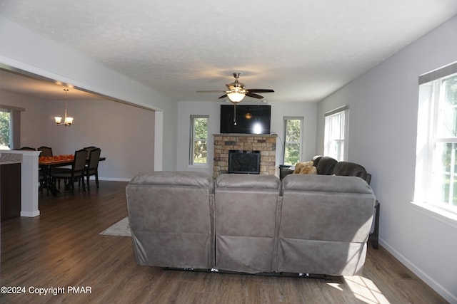 living room with a textured ceiling, a fireplace, dark hardwood / wood-style floors, and a healthy amount of sunlight