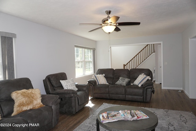 living room featuring ceiling fan and dark hardwood / wood-style flooring