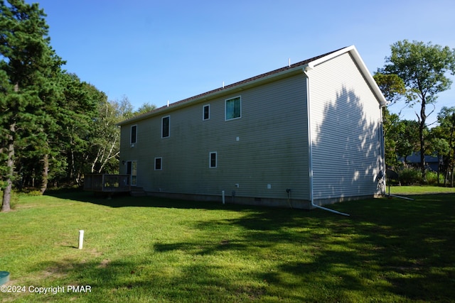 rear view of property featuring a yard and a deck