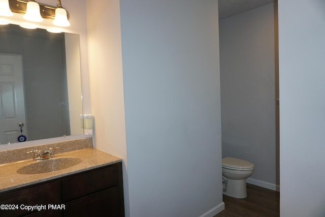 bathroom with hardwood / wood-style flooring, vanity, and toilet