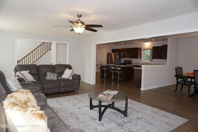 living room with dark hardwood / wood-style floors and ceiling fan