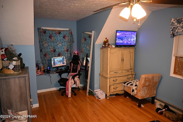 bedroom with a textured ceiling, ceiling fan, light wood finished floors, and baseboards