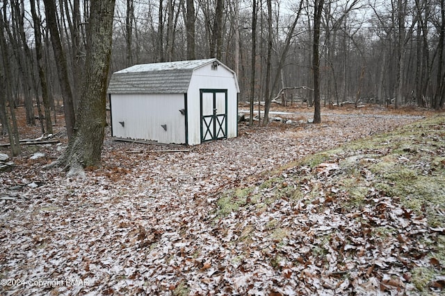 view of shed with a wooded view