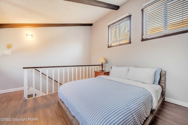 bedroom with dark wood-type flooring and beamed ceiling