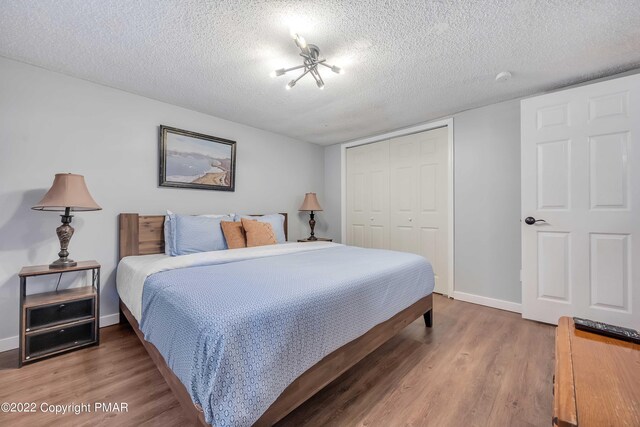 bedroom with hardwood / wood-style flooring, a closet, and a textured ceiling