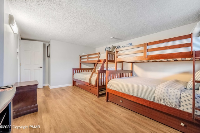 bedroom featuring a textured ceiling and light wood-type flooring