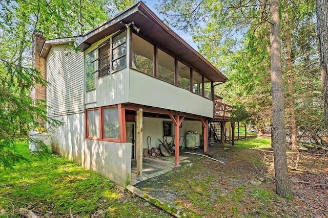 1125 Rhododendron Ln, Pocono Summit, PA 18346 - view of side of home with a chimney, a sunroom, stairs, a deck, and stucco siding
