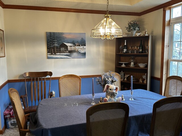 dining space with a notable chandelier and ornamental molding