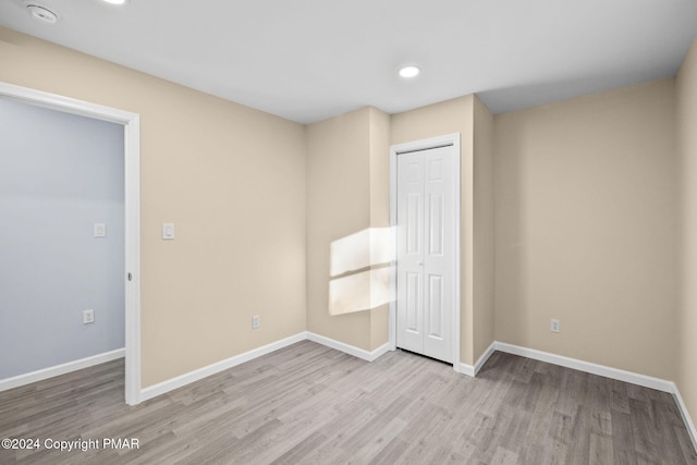 unfurnished bedroom featuring recessed lighting, a closet, baseboards, and wood finished floors