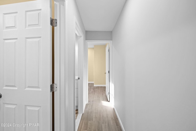 hallway with baseboards and wood finished floors