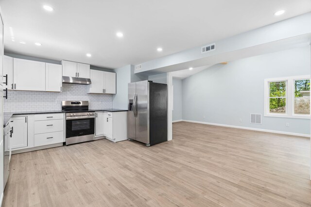 410 Sunset Forest Dr, Hawley, PA 18428 - kitchen with stainless steel appliances, under cabinet range hood, dark countertops, backsplash, and light wood-style floors