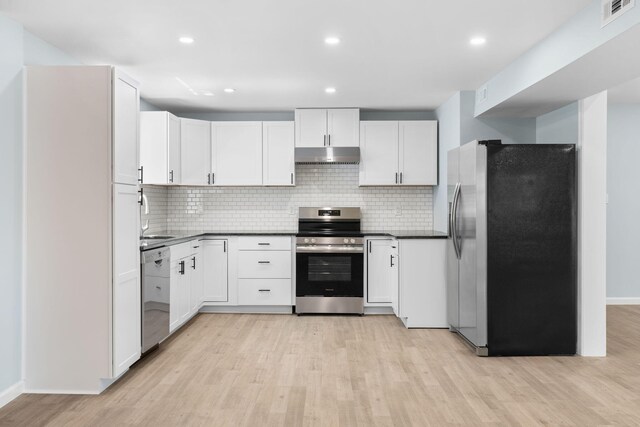 410 Sunset Forest Dr, Hawley, PA 18428 - kitchen with stainless steel appliances, under cabinet range hood, light wood finished floors, dark countertops, and backsplash