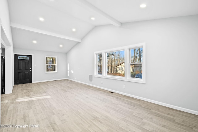 unfurnished living room with vaulted ceiling with beams, light wood-style floors, baseboards, and visible vents