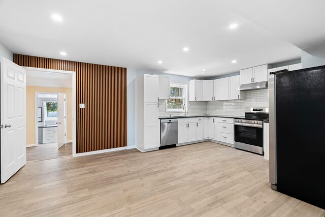 410 Sunset Forest Dr, Hawley, PA 18428 - kitchen featuring stainless steel appliances, a sink, tasteful backsplash, light wood-style floors, and under cabinet range hood